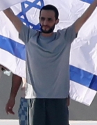 epa12450677 Released Israeli hostage Nimrod Cohen poses with an Israeli flag as after he arrives on to the helipad of the Ichilov Hospital in Tel Aviv, Israel, 13 October 2025. The first phase of the Gaza peace agreement, reached between Israel an...