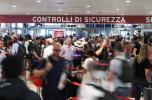 Decine di persone si avvicinano ai varchi di sicurezza all’aeroporto di Bologna