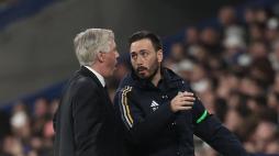Real Madrid's Italian coach Carlo Ancelotti (L) speaks with Real Madrid's Italian assistant coach Davide Ancelotti during the Spanish league football match between Real Madrid CF and Club Atletico de Madrid at the Santiago Bernabeu stadium in Madrid on February 4, 2024. (Photo by Thomas COEX / AFP)