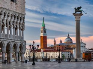 View from St Mark's Square to the church of San Giorgio Maggiore with the Doge's Palace (Palazzo Ducale) on the left. The winged lion of St Mark is the symbol of the city of Venice - Venice, Italy