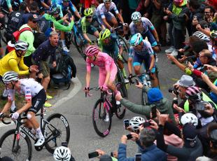 Pink jersey Team UAE's Slovenian rider Tadej Pogacar (C) climbs the Mortirolo section surrounded by fans during the 15th stage of the 107th Giro d'Italia cycling race, 222km between Manerba del Garda and Mottolino on May 19, 2024. (Photo by Luca Bettini / AFP)