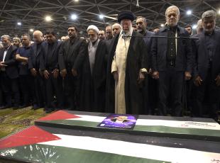 In this photo released by the official website of the office of the Iranian supreme leader, Supreme Leader Ayatollah Ali Khamenei, third right, leads a prayer over the coffins of Hamas leader Ismail Haniyeh and his bodyguard who were killed in an assassination blamed on Israel on Wednesday, during their funeral ceremony at the Tehran University campus, in Tehran, Iran, Thursday, Aug. 1, 2024. Iranian President Masoud Pezeshkian prays at second right. (Office of the Iranian Supreme Leader via AP)