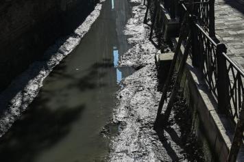 Venezia e la bassa marea: canali in secca e gondole nel fango