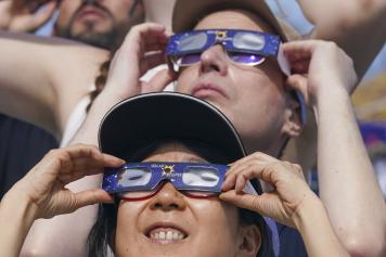 People use special glasses to watch a total solar eclipse in Mazatlan, Mexico, Monday, April 8, 2024. (AP Photo/Fernando Llano)