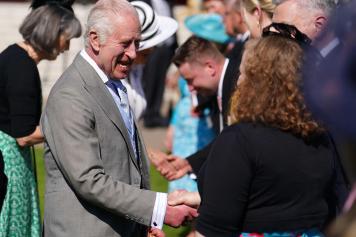 Britain's King Charles III speaks to guests as he hosts a Royal Garden Party at Buckingham Palace in central London, on May 8, 2024. (Photo by Jordan Pettitt / POOL / AFP)