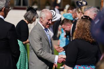 LONDON, ENGLAND - MAY 8: King Charles III speaks to guests attending a Royal Garden Party at Buckingham Palace on May 8, 2024 in London, England.  (Photo by Jordan Pettitt - Pool/Getty Images)