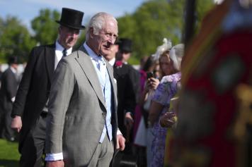 Britain's King Charles III speaks to guests attending a Royal Garden Party at Buckingham Palace, London, Wednesday May 8, 2024. (Jordan Pettitt/Pool via AP)