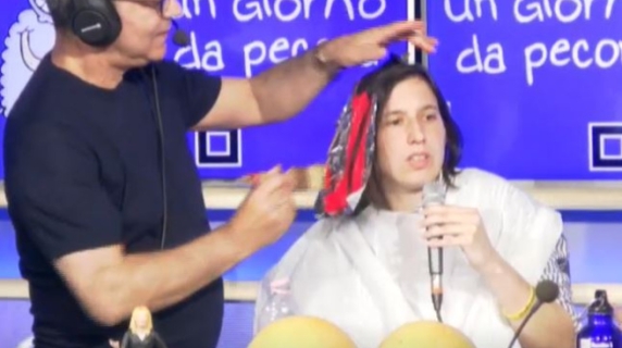 Schlein mantiene la parola e tinge una ciocca di rosso, poi la stoccata a Meloni: «Che canzone le dedico? ‘Lo scrutatore non votante’»