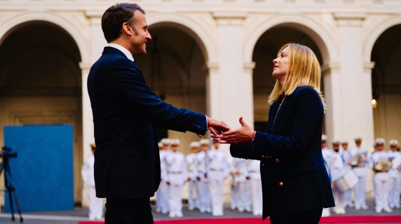 Meloni accoglie Macron a Palazzo Chigi: scambio di baci e larghi sorrisi