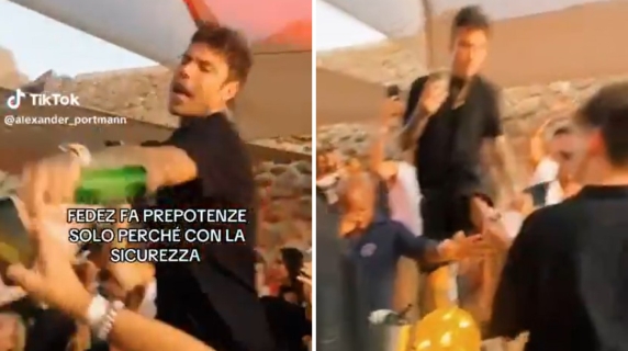 Fedez infastidito dal ragazzo che lo riprende mentre balla sul tavolo di un locale a Porto Cervo: sferra un calcio per allontanarlo