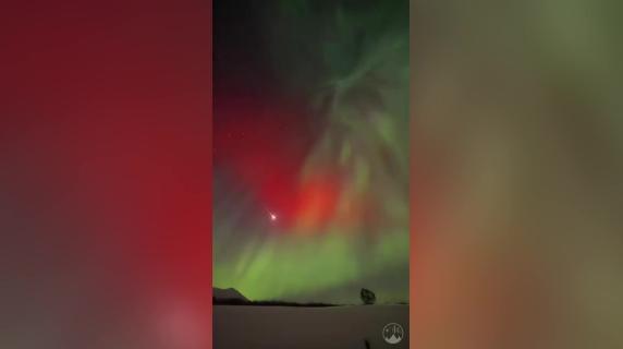 Una meteora attraversa il cielo durante l'aurora boreale in Norvegia