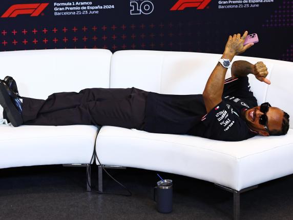 BARCELONA, SPAIN - JUNE 23: Third placed Lewis Hamilton of Great Britain and Mercedes lies on the softa as he waits for a press conference after the F1 Grand Prix of Spain at Circuit de Barcelona-Catalunya on June 23, 2024 in Barcelona, Spain. (Photo by Clive Rose/Getty Images)