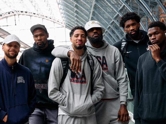 Members of the US Olympic Basketball team, Stephen Curry, Kevin Durant, Tyrese Haliburton, Lebron James, Joel Embiid, and Anthony Edwards, pose for a photo before boarding an Olympic-themed Golden Train as they prepare to travel to Paris to attend the Paris 2024 Olympic Games, from the Eurostar departures terminal at St Pancras International train station in London on July 24, 2024. (Photo by BENJAMIN CREMEL / AFP)
