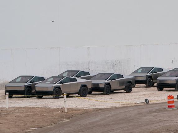 (FILES) Newly manufactured Tesla Cybertrucks are parked outside the company's Giga Texas factory on December 13, 2023, in Austin, Texas. Tesla is recalling 3,878 Cybertruck vehicles because of a defect that can cause unintentional vehicle acceleration, increasing crash risk, according to a US notice posted this week. Tesla notified the National Highway Traffic Safety Administration on April 17, 2024, of the condition in which the accelerator pedal may become trapped. (Photo by SUZANNE CORDEIRO / AFP)