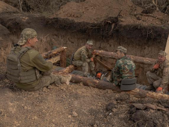 In this photo taken on April 4, 2024, Ukrainian servicemen take a break as they prepare a trench system in the Donetsk region, amid the Russian invasion of Ukraine. (Photo by Roman PILIPEY / AFP)