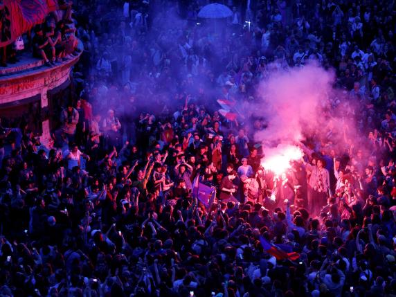 People gather during an election night event following the first results of the second round of France's legislative election at Republique Square in Paris on July 7, 2024. A broad left-wing coalition was leading a tight French legislative election, ahead of both President's centrists and the far right with no group winning an absolute majority, projections showed. (Photo by GEOFFROY VAN DER HASSELT / AFP)