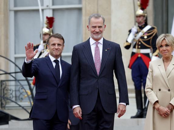 France's President Emmanuel Macron (L) and his wife Brigitte Macron (R) greet Spain's King  Felipe VI (C) on arrival ahead of a reception for heads of state and governments ahead of the opening ceremony of the Paris 2024 Olympic Games, at the Elysee presidential palace in Paris, on July 26, 2024. (Photo by Valentine CHAPUIS / AFP)