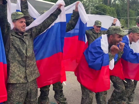 This video grab taken from a handout footage released by the Russian Defence Ministry on July 4, 2025, shows Russian prisoners of war (POWs) posing with Russian national flags following an exchange of prisoners at an undisclosed location in Belarus. Russia and Ukraine announced a fresh prisoner swap on July 4, 2025, part of agreements reached between Moscow and Kyiv during talks in Istanbul last month. (Photo by Handout / Russian Defence Ministry / AFP) / RESTRICTED TO EDITORIAL USE - MANDATORY CREDIT "AFP PHOTO / RUSSIAN DEFENCE MINISTRY" - HANDOUT - NO MARKETING NO ADVERTISING CAMPAIGNS - DISTRIBUTED AS A SERVICE TO CLIENTS - AFP CANNOT INDEPENDENTLY VERIFY THE AUTHENTICITY OR LOCATION, DATE, AND CONTENT OF THESE IMAGES. /