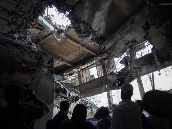 People stand inside a destroyed room at the Evin prison after Israeli air strikes the previous month, in Tehran, on July 1, 2025. Israel on June 13 launched a major bombing campaign against Iran, killing top military commanders and atomic scientists. Iran retaliated with waves of missiles and drone strikes which hit major cities in Israel including Tel Aviv and Haifa, killing 28 people, according to Israeli authorities. A ceasefire between Iran and Israel took effect on June 24. (Photo by AFP)