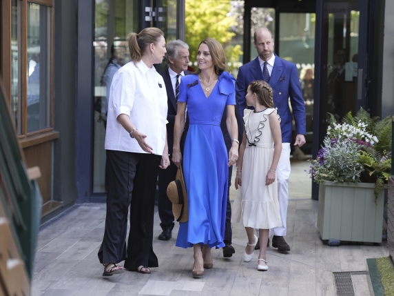 Britain's Prince William, Kate, Princess of Wales, center, and Princess Charlotte are greeted by Sally Ambrose, left, a member of the Committee of Management of The Championships, as they arrive to attend the men's singles final match between Italy's Jannik Sinner and Spain's Carlos Alcaraz at the Wimbledon Tennis Championships in London Sunday July 13, 2025. (Andrew Matthews/Pool via AP)