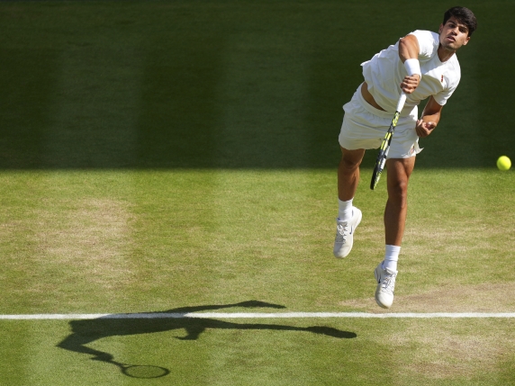 Carlos Alcaraz of Spain serves to Italy's Jannik Sinner in the men's singles final at the Wimbledon Tennis Championships in London, Sunday, July 13, 2025. (AP Photo/Joanna Chan)