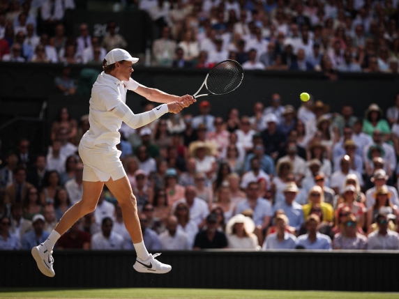 Italy's Jannik Sinner plays a backhand return to Spain's Carlos Alcaraz during their men's singles final tennis match on the fourteenth day of the 2025 Wimbledon Championships at The All England Lawn Tennis and Croquet Club in Wimbledon, southwest London, on July 13, 2025. (Photo by HENRY NICHOLLS / AFP) / RESTRICTED TO EDITORIAL USE