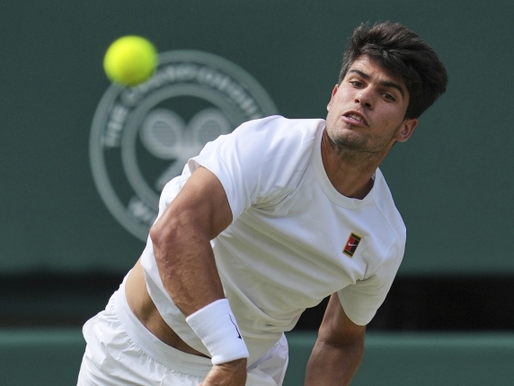 Carlos Alcaraz of Spain serves to Italy's Jannik Sinner in the men's singles final at the Wimbledon Tennis Championships in London, Sunday, July 13, 2025. (AP Photo/Kin Cheung)