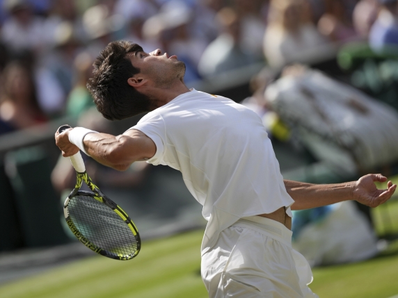 Carlos Alcaraz of Spain serves to Italy's Jannik Sinner in the men's singles final at the Wimbledon Tennis Championships in London, Sunday, July 13, 2025. (AP Photo/Kin Cheung)