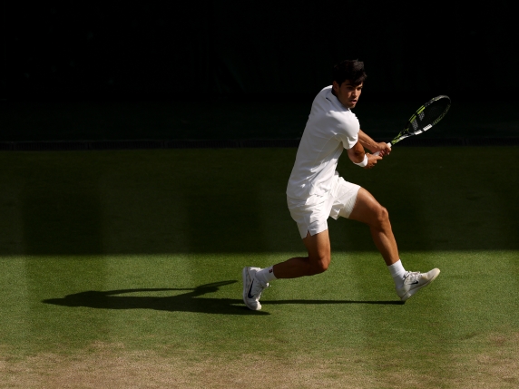 LONDON, ENGLAND - JULY 13: Carlos Alcaraz of Spain plays a backhand against Jannik Sinner of Italy during the Gentleman's Singles Final on day fourteen of The Championships Wimbledon 2025 at All England Lawn Tennis and Croquet Club on July 13, 2025 in London, England. (Photo by Ezra Shaw/Getty Images)