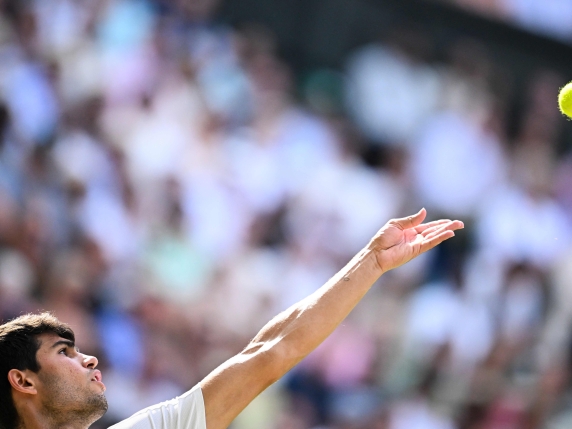 Spain's Carlos Alcaraz serves to Italy's Jannik Sinner during their men's singles final tennis match on the fourteenth day of the 2025 Wimbledon Championships at The All England Lawn Tennis and Croquet Club in Wimbledon, southwest London, on July 13, 2025. (Photo by Kirill KUDRYAVTSEV / AFP) / RESTRICTED TO EDITORIAL USE