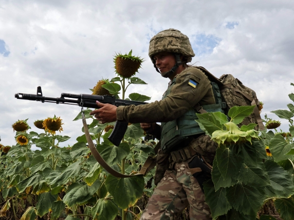 This handout photograph taken and released by the press service of the 65th Mechanized Brigade of Ukrainian Armed Forces on August 11, 2025, shows Julia, 40, a new recruit, taking part in a training exercise in a sunflowers field at an undisclosed...