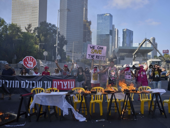Demonstrators block a highway and burn an installation of a Shabbat dinner table demanding the immediate release of hostages held by Hamas and calling for the Israeli government to reverse its decision to take over Gaza City and other areas in the...