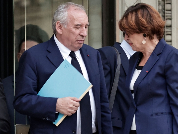 France's Prime Minister Francois Bayrou, flanked by France's Minister for Agriculture and Food Sovereignty Annie Genevard (R), leaves the National Assembly after the result of a confidence vote over the government's austerity budget, at the Nation...