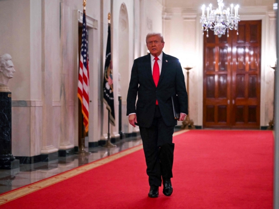 US President Donald Trump walks toward the East Room of the White House for a ballroom dinner in Washington, DC, on October 15, 2025. (Photo by ANDREW CABALLERO-REYNOLDS / AFP)