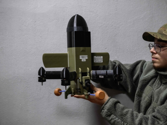 A member of the 3rd Army Corps Interception Squadron holds an interceptor drone used to protect against Russian drone attacks, at an undisclosed location near the front lines of eastern Uraine, on October 9, 2025. (Photo by Ed JONES / AFP)