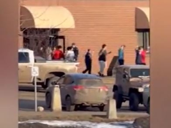 Gli studenti escono da scuola in fila indiana e con le mani alzate