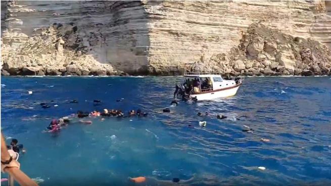 I turisti cercano di salvare i migranti arrivati a Lampedusa, ma qualcuno non ce la fa: le immagini drammatiche