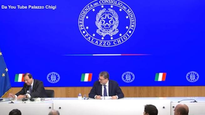 Si rompe un bicchiere in conferenza stampa, Giorgetti: «Porta bene?»