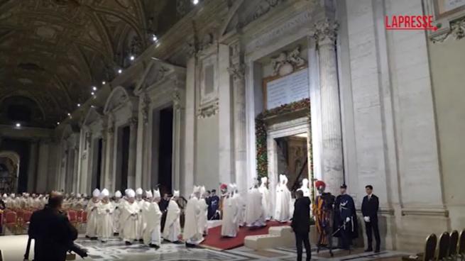 Papa Francesco varca la Porta Santa seguito da una fila di sacerdoti