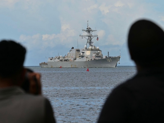 Photographers take pictures as the USS Gravely warship enters the port of Port of Spain on October 26, 2025. The US warship will visit Trinidad and Tobago for joint exercises near the coast of Venezuela amid Washington's campaign against alleged d...