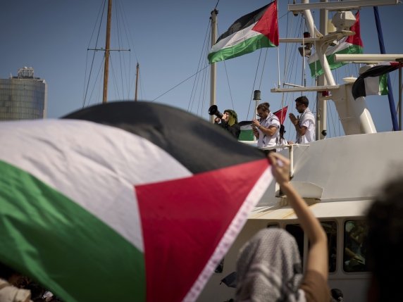 Demonstrators shout slogans on a boat ahead of the launch of a civilian flotilla bound for Gaza, aiming to break the Israeli blockade and deliver humanitarian aid in Barcelona, Spain, Sunday, Aug. 31, 2025. (AP Photo/Emilio Morenatti)