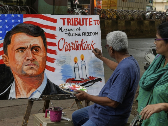 A teacher from Gurukul school of Art completes artwork to pay tribute to Charlie Kirk who was shot and killed, in Mumbai, India, Thursday, Sept. 11, 2025. (AP Photo/Rajanish Kakade)