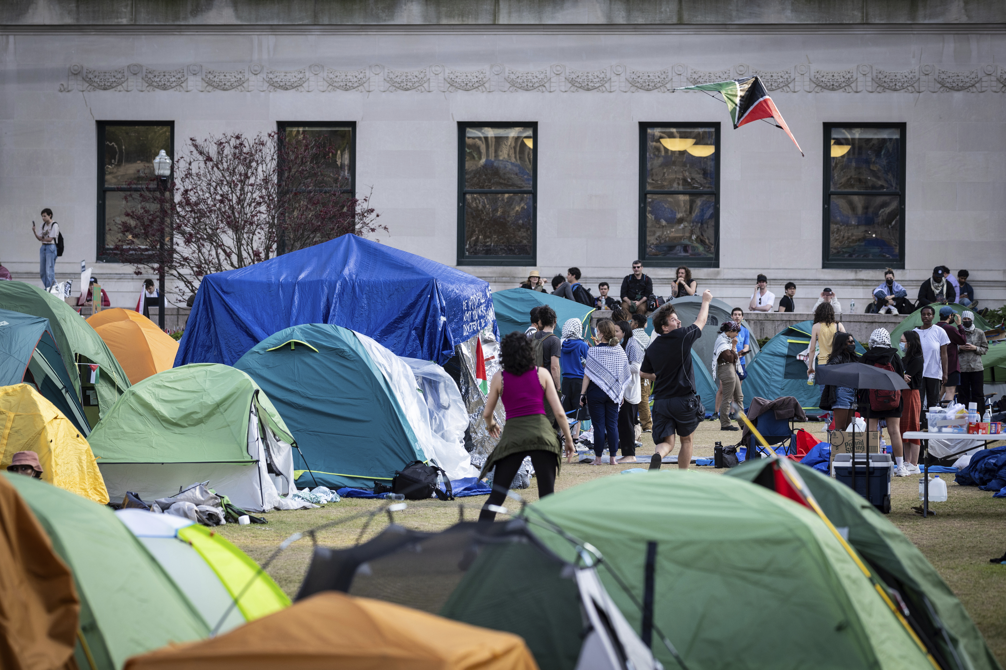 A student protester flys a kite inside the protest encampment on the Columbia University campus, Monday, April 29, 2024, in New York. Protesters of the war in Gaza who are encamped at Columbia University have defied a deadline to disband with chants, clapping and drumming. (AP Photo/Stefan Jeremiah)