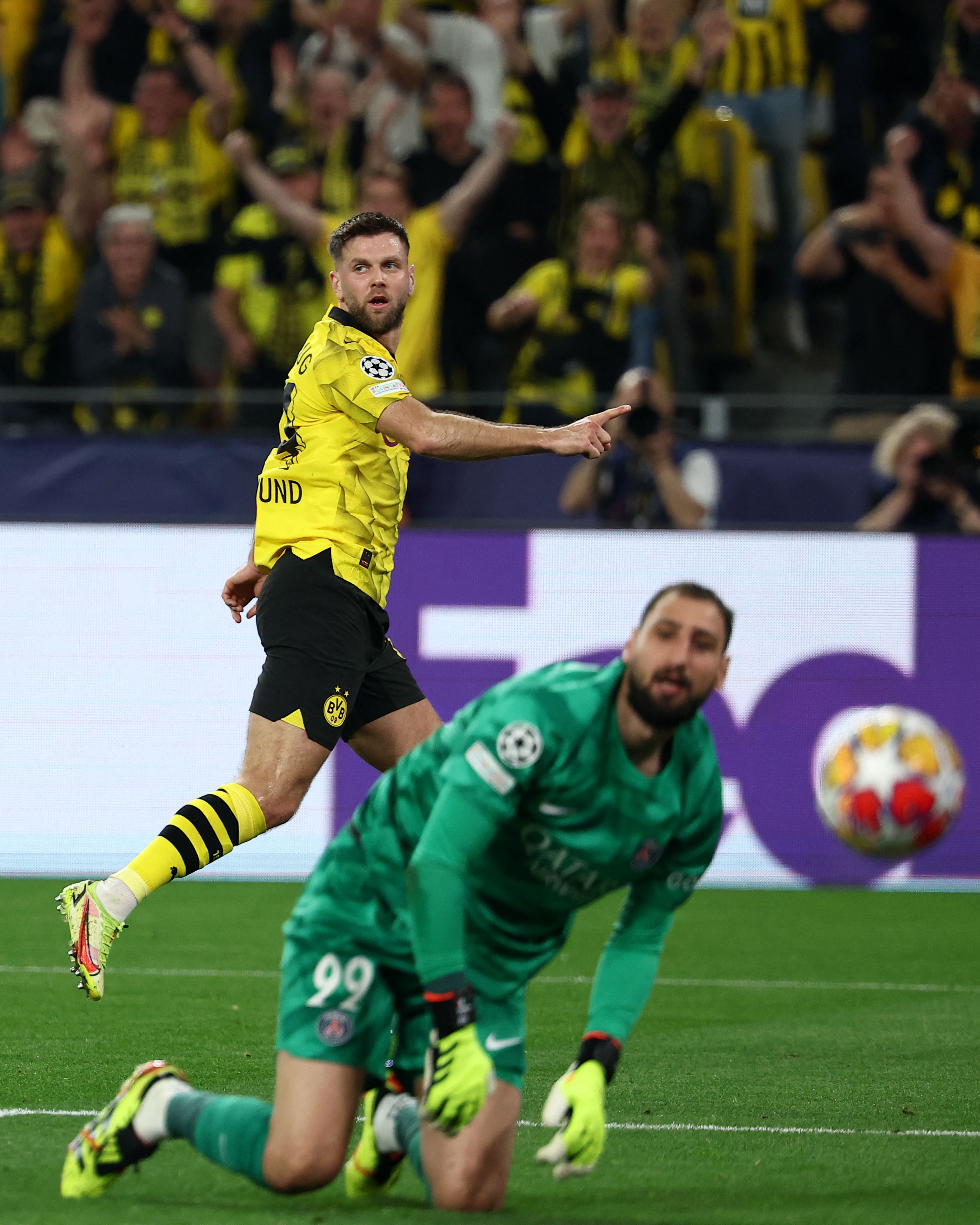 Dortmund's German forward #14 Niclas Fuellkrug (L) celebrates scoring the opening goal next to Paris Saint-Germain's Italian goalkeeper #99 Gianluigi Donnarumma reacts during the UEFA Champions League semi-final first leg football match between Borussia Dortmund and Paris Saint-Germain (PSG) in Dortmund, western Germany on May 1, 2024. (Photo by FRANCK FIFE / AFP)