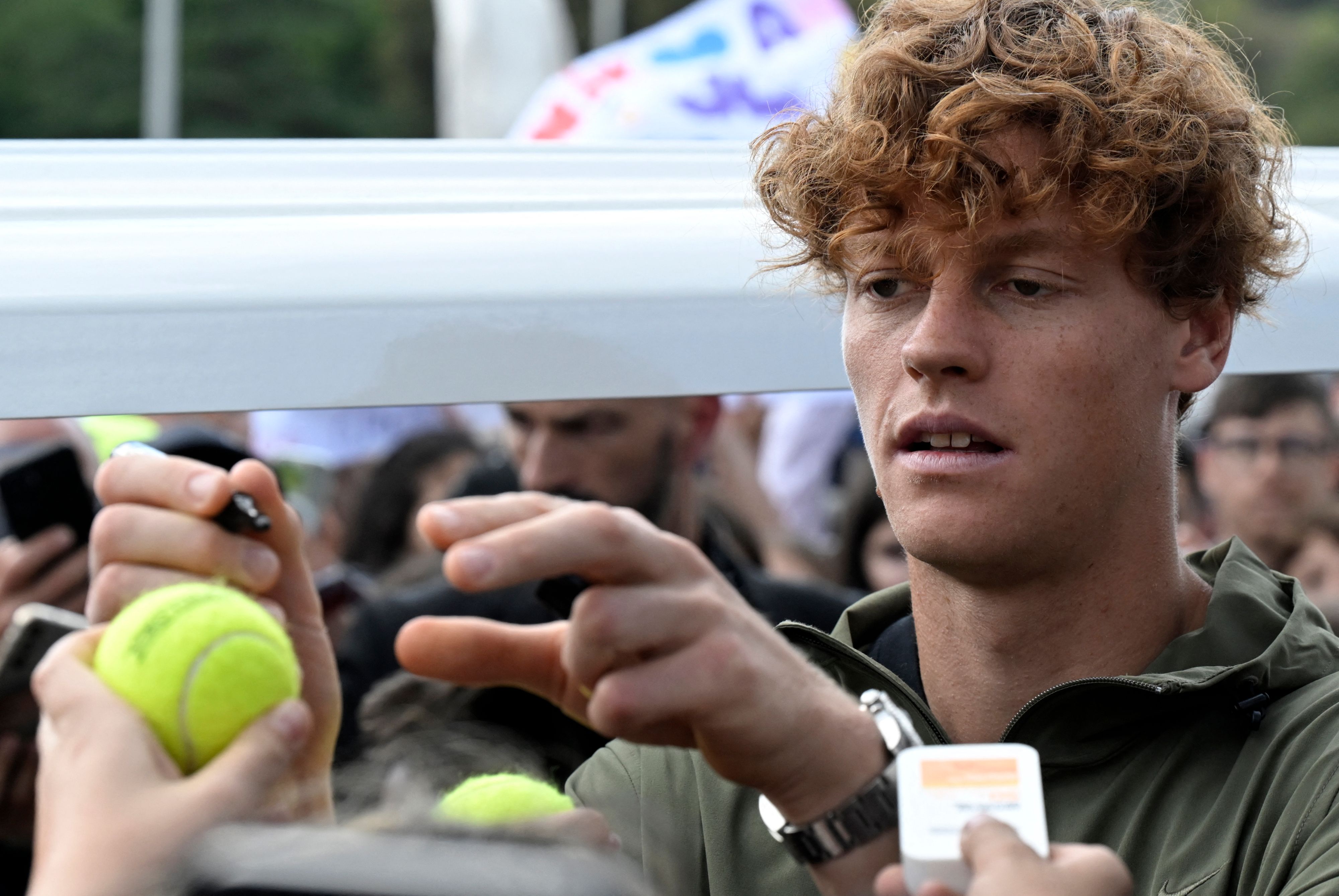 Italian player Jannik Sinner signs autographs during a visit at the Italian Open on May 07, 2024 at the Foro Italico in Rome. Australian Open champion Jannik Sinner said on May 02, 2024  that he will only compete at the French Open if he is fully fit after being forced to withdraw injured from this week's Italian Open. (Photo by Tiziana FABI / AFP)