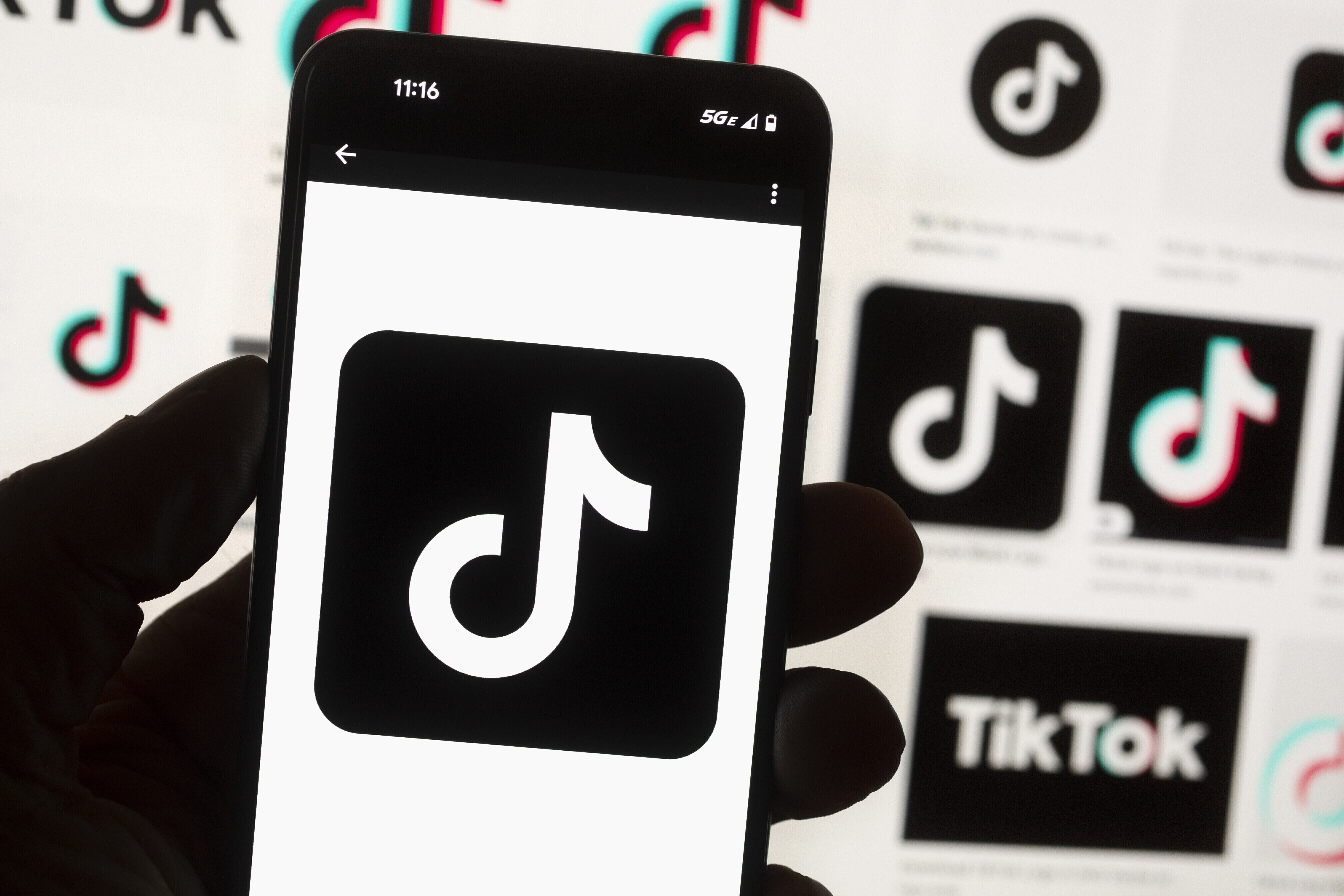 FILE - The TikTok logo is displayed on a mobile phone in front of a computer screen, Oct. 14, 2022, in Boston. On Tuesday, May 7, 2024, TikTok and its Chinese parent company ByteDance filed suit against the U.S. federal government to challenge a law that would force the sale of ByteDance's stake or face a ban, saying that the law is unconstitutional. (AP Photo/Michael Dwyer, File)