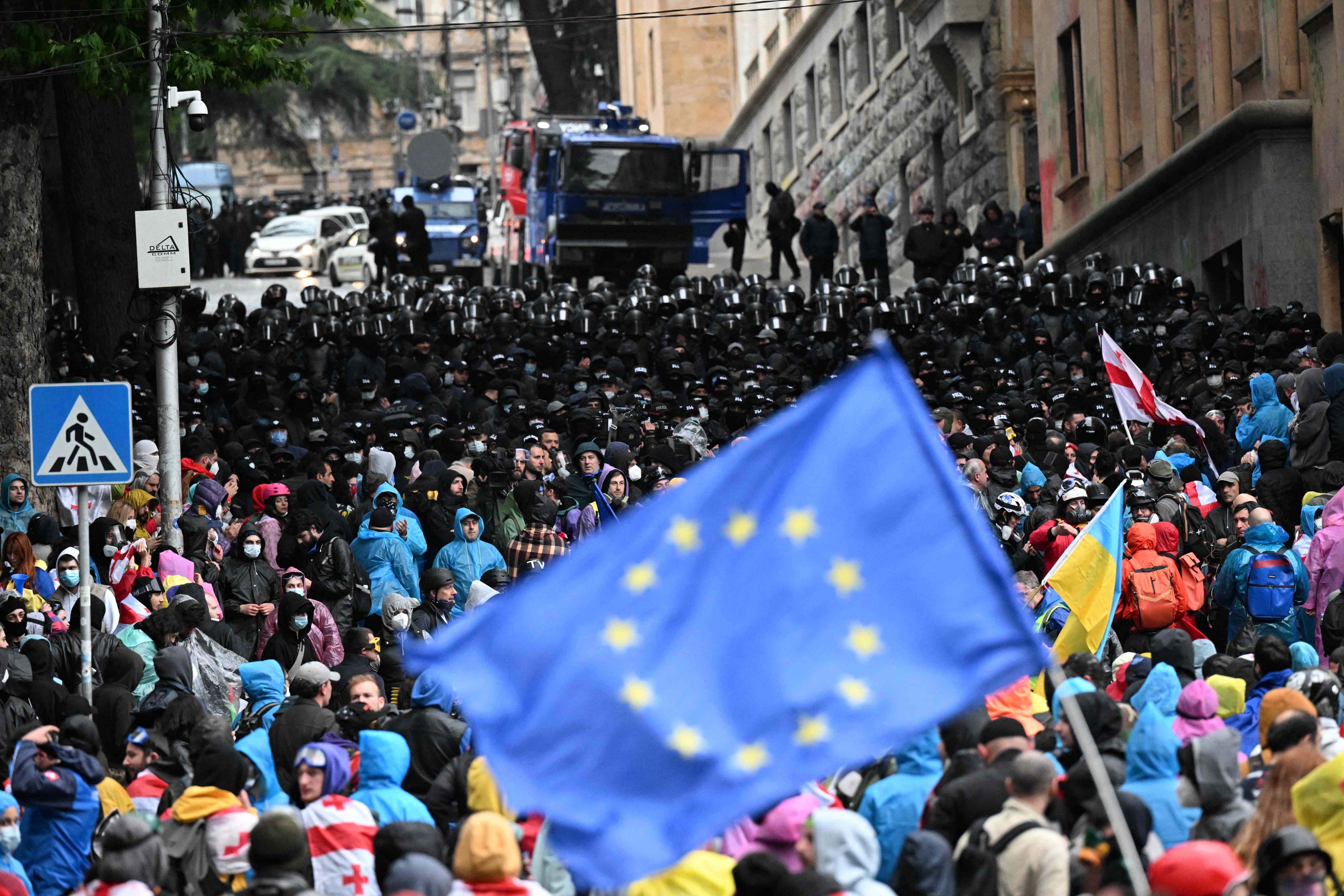 Demonstrators protest the controversial "foreign influence" bill near the parliament in Tbilisi on May 13, 2024. Several thousand Georgians gathered outside parliament in Tbilisi on May 12,  in a fresh protest against a Russian-styled "foreign agent" bill, despite government officials warning of arrests. (Photo by Vano SHLAMOV / AFP)