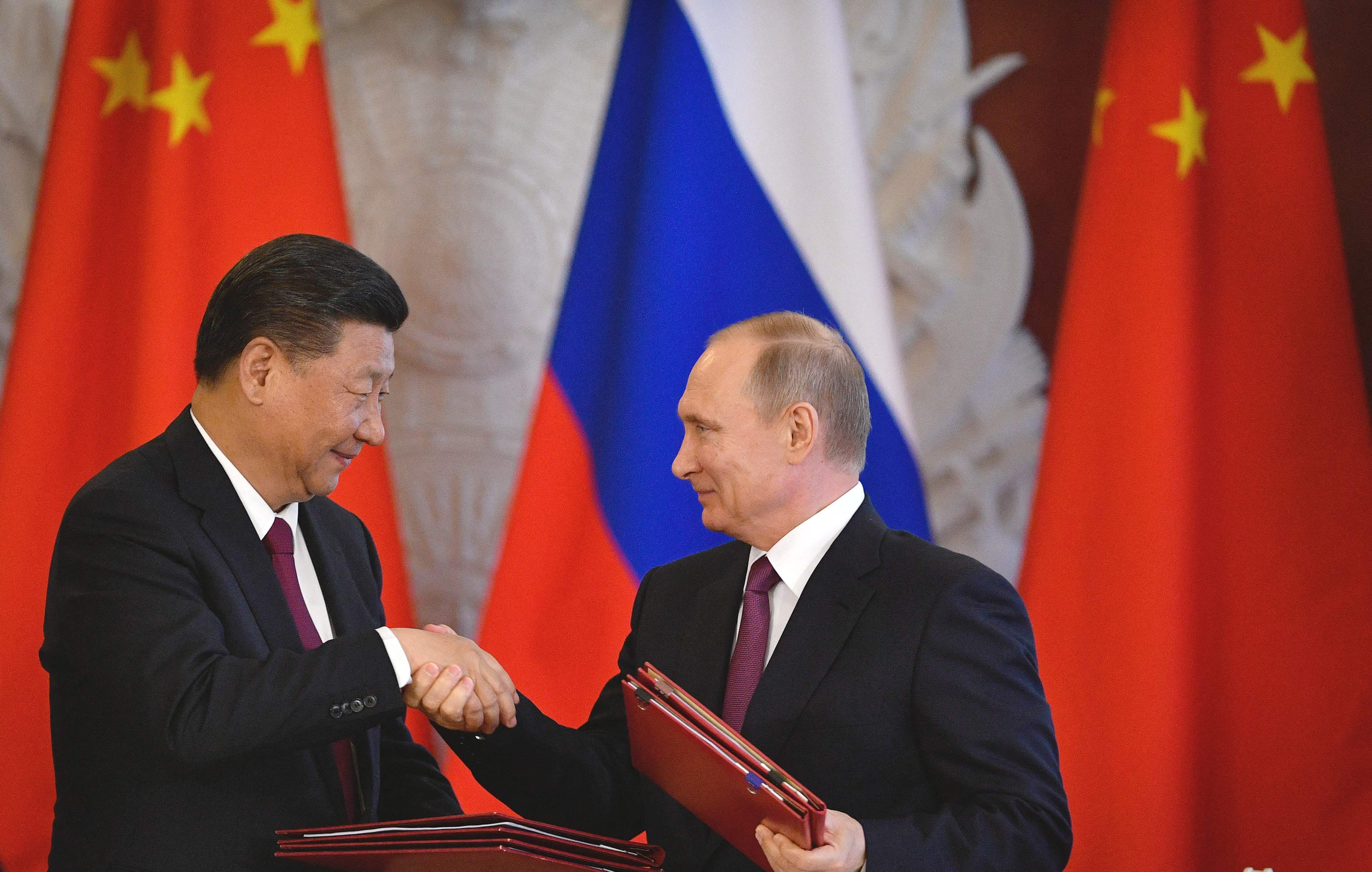 (FILES) Russia's President Vladimir Putin (R) and China's President Xi Jinping shake hands during a signing ceremony in the Kremlin in Moscow on July 4, 2017. Russian President Vladimir Putin will visit China this week on the invitation of leader Xi Jinping, Beijing's foreign ministry said May 14, 2024. (Photo by Alexander NEMENOV / AFP)