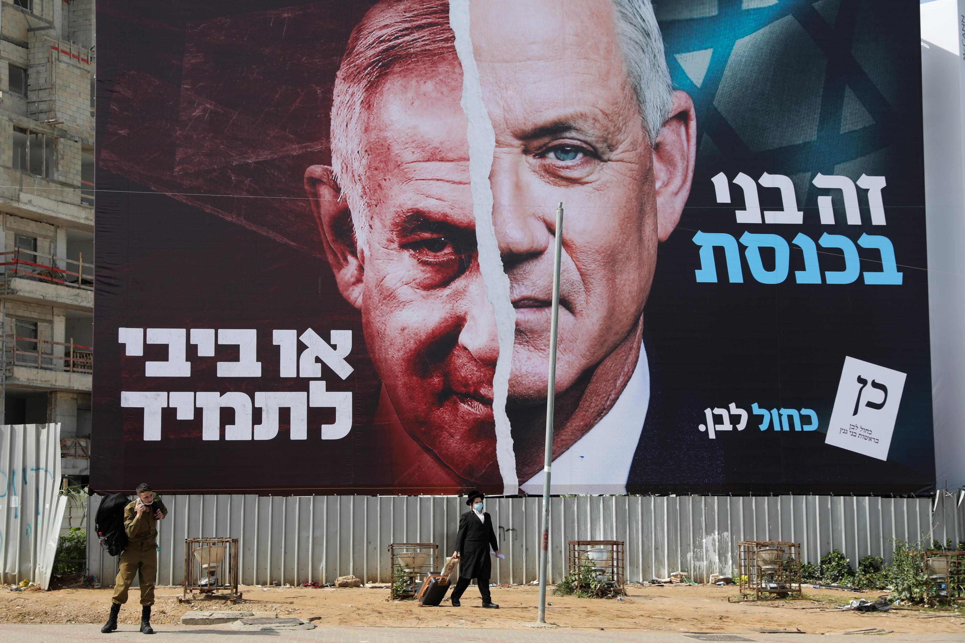 epa09073380 People pass by a large election billboard showing Israeli Prime Minister Benjamin Netanyahu and leader of the Blue and white party Beny Gantz in Bnei Brak, near Tel Aviv, Israel, 14 March 2021. Israel is expected to hold legislative elections on 23 March 2021 to elect the members of the 24th Knesset.  EPA/ABIR SULTAN