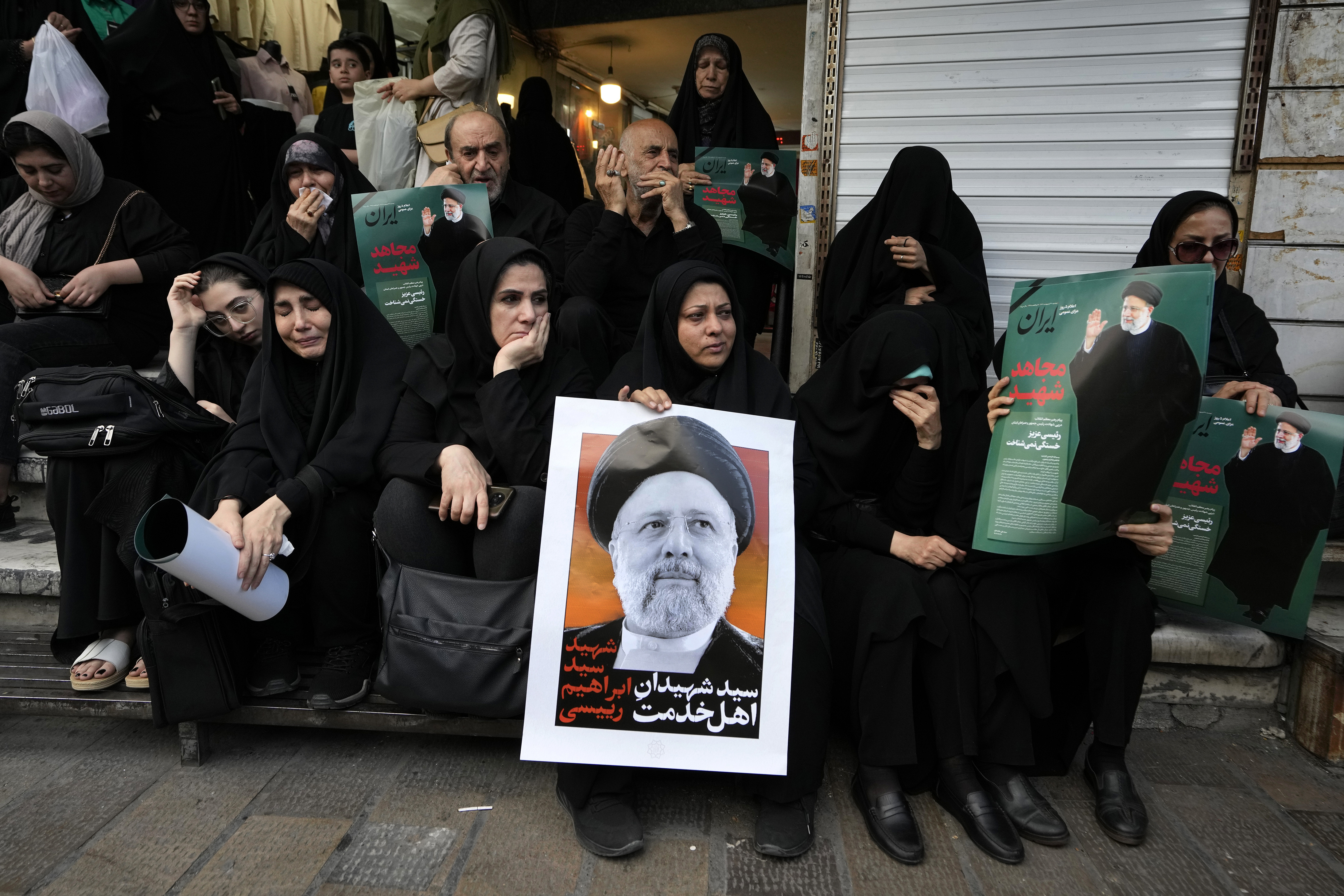 People hold up posters of Iranian President Ebrahim Raisi during a mourning ceremony for him at Vali-e-Asr square in downtown Tehran, Iran, Monday, May 20, 2024. President Raisi and the country's foreign minister were found dead Monday hours after their helicopter crashed in fog, leaving the Islamic Republic without two key leaders as extraordinary tensions grip the wider Middle East. (AP Photo/Vahid Salemi)